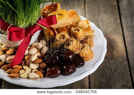 Nowruz Holiday Concept - Grass, Baklava Sweets, Nuts And Seeds, Copy Space