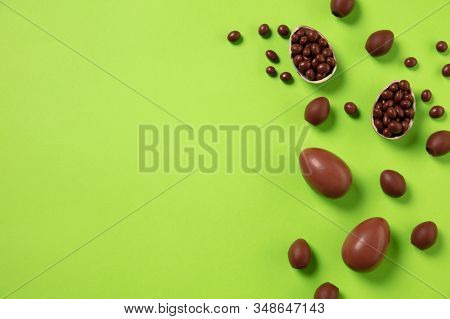 Egg Hunt Is Coming. Easter Traditions, Chocolate Eggs On Green Background, Top View, Copyspace For Y