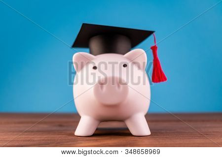Piggy Bank With A Graduation Hat On A Light Blue Backround. Student Scolarship Save Concept. Finance