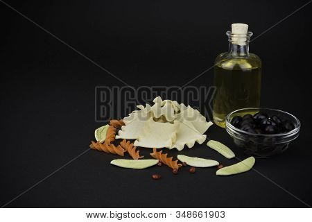 Different Spaghetti And Olive Oil On Black Background. Pasta.