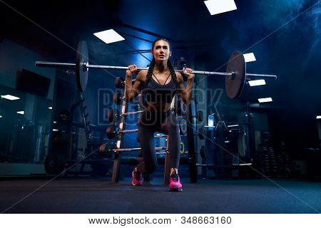 From Below View Of Brunette Female Bodybuilder With Braids Doing Squats Using Barbell. Srtong Woman 