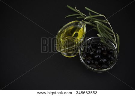 Olive Oil With Olives On Black Background.