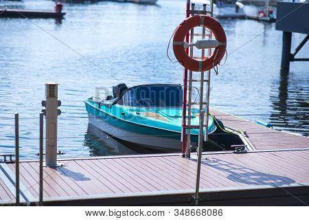 Small Motor Boat At Anchor By Rope In Replot Pier