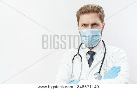 Potrait Of Middle-aged Doctor Wearing Face Mask, Stethoscope, And Blue Rubber Gloves Standing With C