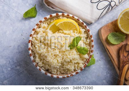 Couscous With Mint And Lemon In Plate On Dark Rustic Table From Above. Copy Space For Text. Flat Lay