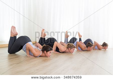 Group Of Young Sporty Sexy Women In Yoga Studio, Practicing Yoga Lesson With Instructor, Forming A L