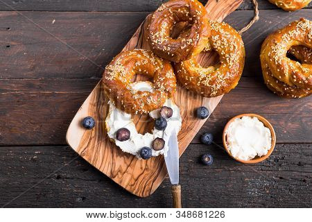 Bagels Sandwich With Cream Cheese And Blueberry On Wooden Table. Bagel. Heap Of Fresh Baked Bagels O