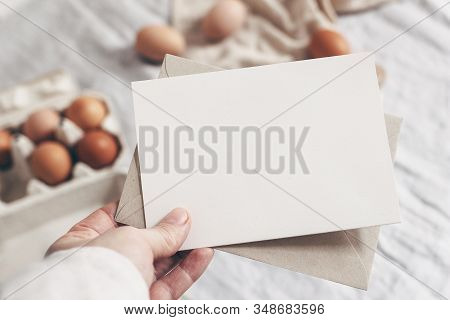 Closeup Of Womans Hand Holding Blank Paper Card. Greeting Card Mock-up Scene. Spring, Easter Design.