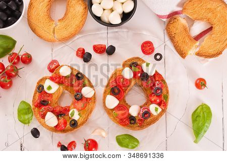 Friselle With Tomatoes And Mozzarella Cheese On Wooden Table.