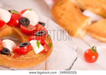 Friselle With Tomatoes And Mozzarella Cheese On Wooden Table.