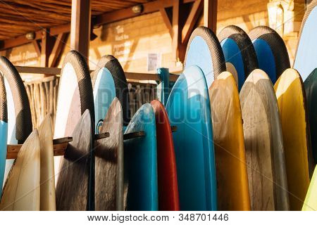 Set Of Different Color Surf Boards In A Stack By Ocean.bali.indonesia. Surf Boards On Sandy Beach Fo
