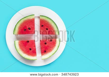 Fresh Slices Of Ripe Red Watermelon On White Round Plate. Cut Watermelon On Blue Background. Top Vie