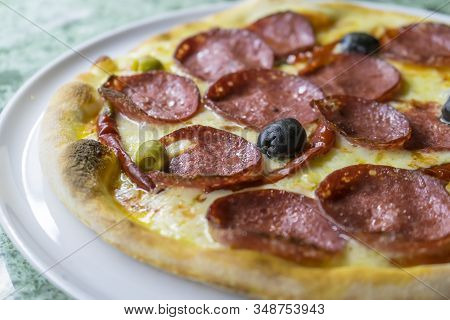 Spicy Devil's Pizza With Salami Slices And Red Pepper Pods Pepperoni And Black Olives