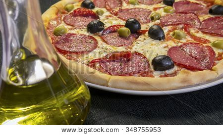 Spicy Devil's Pizza With Salami Slices And Red Pepper Pods Pepperoni And Black Olives