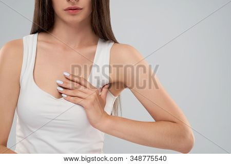 Clolse Up Of Incognito Caucasian Woman In White Shirt Posing Over Gray Isolated Background And Touch
