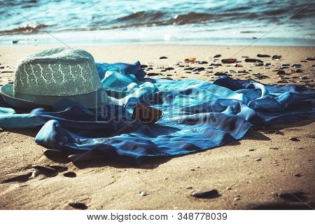 Hat And Beach Tunic On The Beach With The Sea In The Background, Toned, Teal And Orange