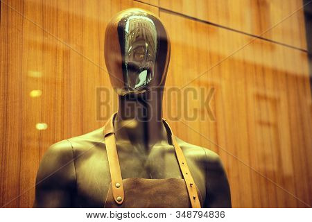 Stylish Black Mannequin In An Apron On A Store Window. Close Up.