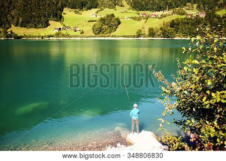 Lake Lungern Switzerland - Famous Fishing Lake In Switzerland. Fisher By The Lake