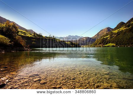 Lake Lungern Switzerland - Famous Fishing Lake In Switzerland. Stones And Reflection In Water