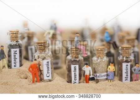 Glass Test-tube With Sand Of Different Summer Vacation Destinations. Located In Sand With Small Peop