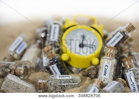 Glass Test-tube With Sand Of Different Summer Vacation Destinations. Located In Sand With Clock. Vac