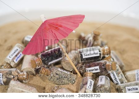 Glass Test-tube With Sand Of Different Summer Vacation Destinations. Vacation Time Abstract Photo.