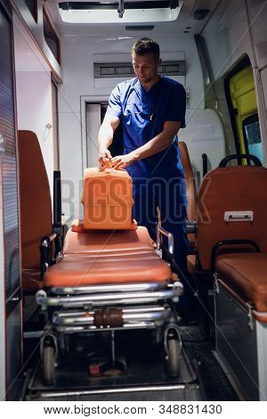 Corpsman Stands With Medical Bag In The Ambulance Car