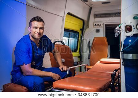 Corpsman In Uniform Sits In The Ambulance Car And Smiles