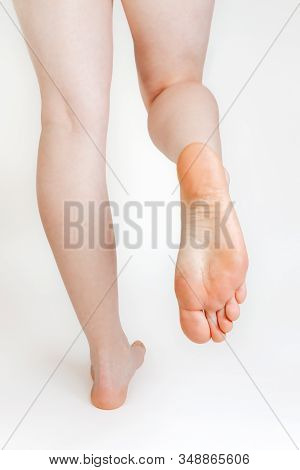 Womens Smooth And Beautiful Feet, On A White Background. The Soles Of The Feet. Cosmetology And Medi