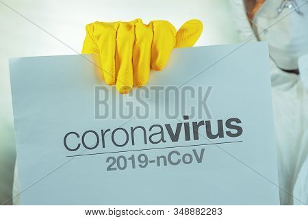 Coronavirus Warning Paper Banner Held By Male Epidemiologist In Protective Clothing