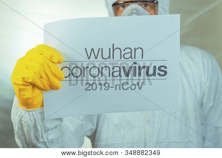 Wuhan Coronavirus Warning Paper Banner Held By Male Epidemiologist In Protective Clothing