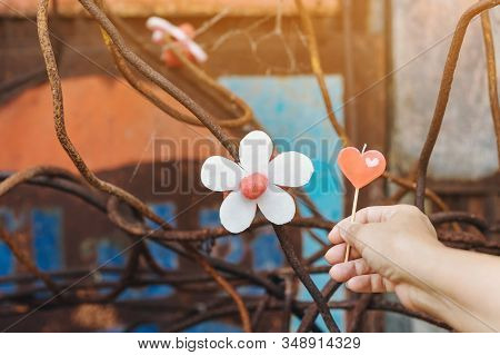A Red Heart-shaped Candle On Woman's Hand And An Artificial Flower Made Of White And Red Candles Wit