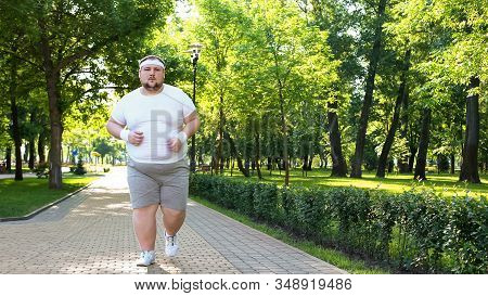 Fat Man Slowly Running Outdoors, Active Lifestyle As Struggle With Obesity
