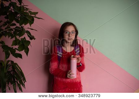 Girl With Cup. Schoolgirl Girl In Glasses Drinks Water From A Thermomug.a Schoolgirl Drinks Tea, Jui