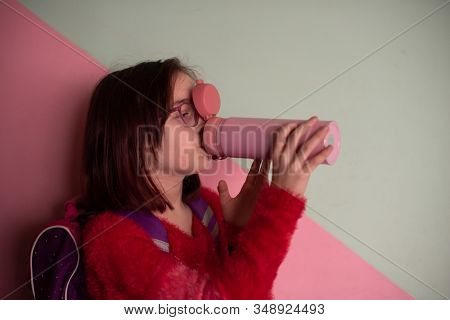 Girl With Cup. Schoolgirl Girl In Glasses Drinks Water From A Thermomug.a Schoolgirl Drinks Tea, Jui