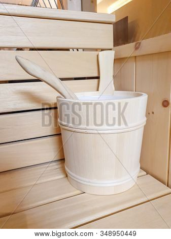 Wooden Bucket And Wooden Scoop Standing On Bench In Sauna