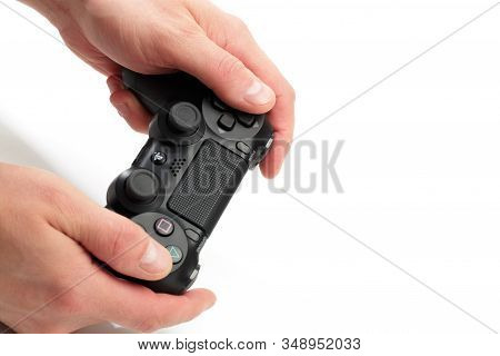 Russia, Oktober 24 2019: Mans Hands Holding  New Sony Dualshock 4 With Playstation 4. Sony Playstati