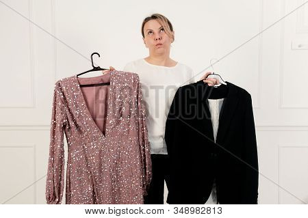 A Woman Has A Difficult Choice, Not Knowing What To Wear. Evening Dress Or Business Suit. Nothing To