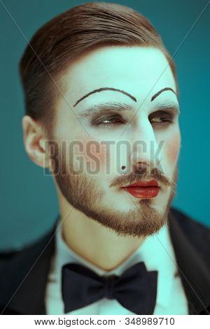 Art and fashion. Portrait of a young man with makeup in the style of the 20s in an elegant suit playing different life roles. Male mime artist.