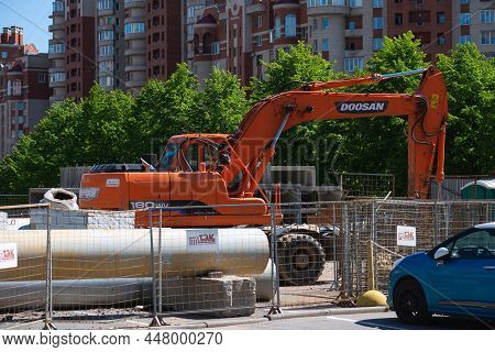 Saint-petersburg, Russia-may 30, 2021: A Fenced Area Of The Territory On Which An Orange Doosan Exca