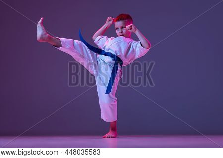 Portrait Of Sportive Kid, Male Taekwondo, Karate Athletes In Doboks Doing Basic Movements Isolated O