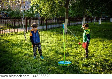 Two Friends Are Playing Tetherball Swing Ball Game In Summer Camping. Two Boy Brother Happy Leisure