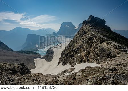 Deep Dropoff From Grinnell Glacier Overlook Into The Valley Below On Hazy Summer Morning