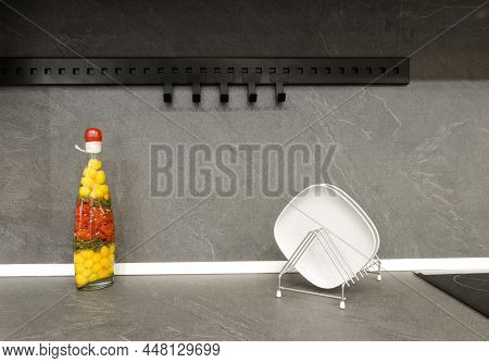 Stand With Plates And A Decorative Bottle On A Dark Gray Countertop In The Kitchen.