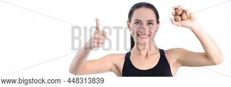 Young Strong Woman Holding Walnuts In Her Hands And Showing Ok Gesture. Healthy Lifestyle Nutrition 
