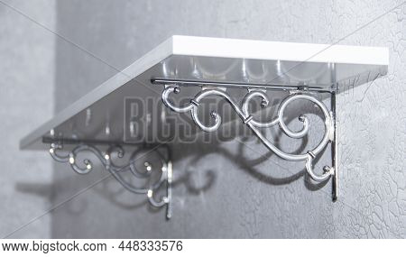 White Wall Shelf On Beautiful Brackets. Empty Wooden Shelves With A White Bracket On The Wall In The