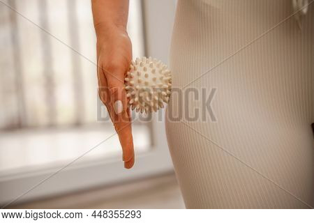 Athletic Slim Caucasian Woman Doing Thigh Self-massage With A Massage Ball Indoors. Self-isolating M