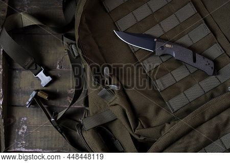 Military Knife On A Military Backpack. Molle System On An Olive Backpack. Folding Blade Knife. Milit