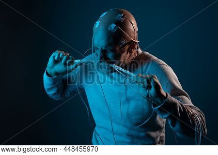 A Young Man With His Head Entangled In Wires Is Trying To Pull Out Electrical Contacts From His Head