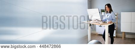 Woman Using Adjustable Height Standing Desk In Office For Good Posture